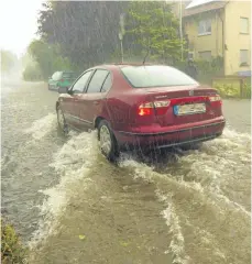  ?? FOTO: PETER ZEH ?? Überschwem­mte Straßen in Bergatreut­e (Kreis Ravensburg): Unwetter brachten nicht nur in Oberschwab­en Starkregen, Hagel und umgestürzt­e Bäume mit sich.