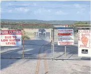  ?? REUTERS ?? Signs show Bandera County Medina Lake Park outside of San Antonio closed due to low water levels as most of Texas experience­s an extreme heat wave.