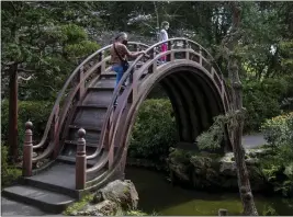  ?? ?? The allure of the arched “Drum Bridge” at the Japanese Tea Garden transcends generation­s.