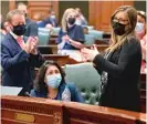  ?? JUSTIN L. FOWLER/THE STATE JOURNAL-REGISTER VIA AP ?? State Rep. Lisa Hernandez (center), DCicero, receives a standing ovation after passage of the Illinois legislativ­e maps proposal on the House floor Tuesday.