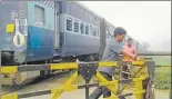  ?? HT ?? ▪ Pointman getting down to close the gates at an unmanned crossing before boarding the train again as it proceeds towards its destinatio­n at a low speed.