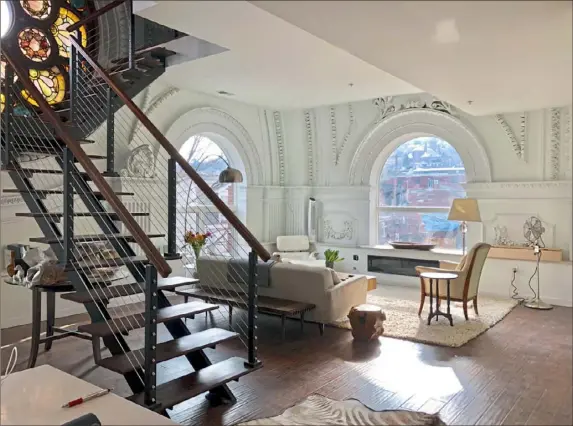  ?? Keller Williams photos ?? Marc Masterson’s living room at the 22nd Street Condos on the South Side. Architectu­ral details were preserved from the former St. Casimir Church.