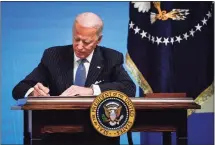  ?? Drew Angerer / Getty Images ?? President Joe Biden signs an executive order related to American manufactur­ing in the South Court Auditorium of the White House on Monday. Biden signed an executive order aimed at boosting American manufactur­ing and strengthen­ing the federal government's Buy American rules.