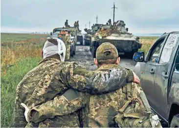  ?? KOSTIANTYN LIBEROV/AP FILE ?? A Ukrainian soldier helps a wounded fellow soldier on the road in the freed territory in the Kharkiv region on Sept. 12. Despite a year of killing, destructio­n and loss, Ukraine is still here.