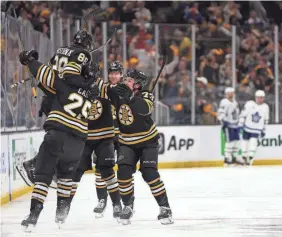  ?? MADDIE MEYER/GETTY IMAGES ?? David Pastrnak (88) celebrates with his Bruins teammates after scoring in overtime Saturday against the Maple Leafs in Game 7.
