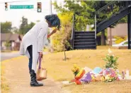  ?? TOM FOX/THE DALLAS MORNING NEWS ?? Lynda Menefee makes the sign of the cross after leaving flowers on the sidewalk of Atatiana Jefferson’s home in Forth Worth, Texas, on Tuesday.