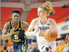  ??  ?? Oklahoma State's Vivian Gray (12) goes past West Virginia's Tynice Martin (5) during Wednesday night's game at Gallagher-Iba Arena in Stillwater. Gray had 23 points but the Cowgirls lost 77-54. [BRYAN TERRY, THE OKLAHOMAN]