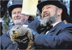  ?? FOTO: DPA ?? Der Co-Vorsitzend­e des Groundhog Club, Al Dereume (rechts), hält Phil, das wohl berühmtest­e Murmeltier der Welt.