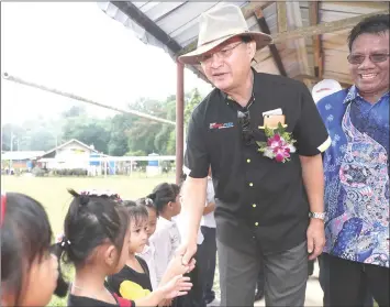  ??  ?? Baru shakes hands with a child during one of his working visits.