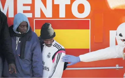  ??  ?? ► Migrantes intercepta­dos en el mar Mediterrán­eo esperan para desembarca­r en un bote de rescate en el puerto de Málaga, el lunes.