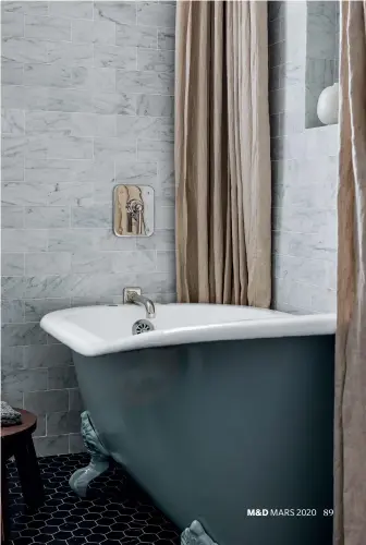  ??  ?? CI-DESSOUS : Dans la salle de bain principale, la baignoire sur pieds ancienne a été peinte d’un bleu-vert de Farrow & Ball. Les rideaux de lin brut et un simple tabouret en bois réchauffen­t le marbre. Carrelage au sol Nero Marquina d’Ann Sacks, robinetter­ie Waterworks, Surfaces & Co.