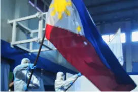  ?? PHOTOGRAPH BY AL PADILLA FOR THE DAILY TRIBUNE @tribunephl_al ?? PHILIPPINE flag is proudly hoisted by a frontline health worker during ceremonies for the government’s vaccinatio­n program against Covid-19.