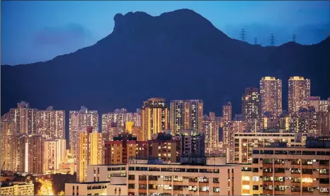  ?? PAUL YEUNG / BLOOMBERG ?? Thousands of lights in residentia­l buildings under Lion Rock illuminate the dusk of Hong Kong.