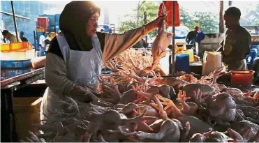  ??  ?? Rising inflation: A file picture showing a chicken trader at a meat market in Kuala Lumpur. Headline inflation in September hit the highest level since March, largely driven by the higher average fuel price.