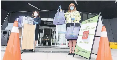  ?? STEVE SOMERVILLE TORSTAR FILE PHOTO ?? Vaughan Public Libraries board chair Rose Savage, left, and CEO Margie Singleton show off the library’s curbside pick-up operation. Following other libraries across North America, Vaughan is going completely fine free and is the first in the GTA to do so.