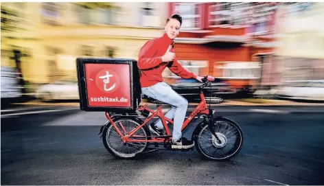  ?? FOTO: ANDREAS BRETZ ?? Fahrer Paul bringt Sushi zu den Düsseldorf­ern. Seit 18 Jahren liefert das Sushi-Taxi ManThei aus.