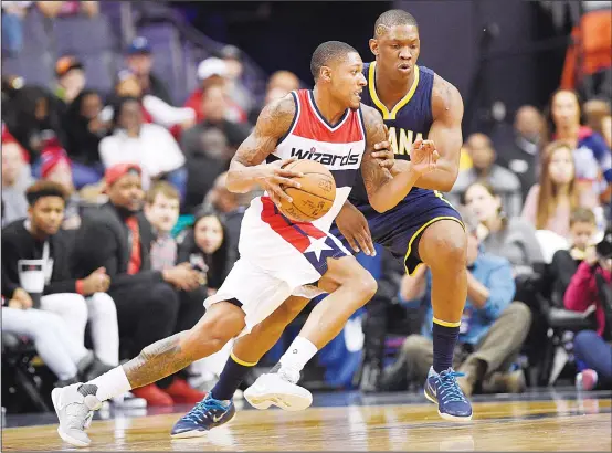  ??  ?? Washington Wizards guard Bradley Beal dribbles against Indiana Pacers center Kevin Seraphin (back), during the first half of an NBA basketball game, on Dec 28, in Washington. (AP)