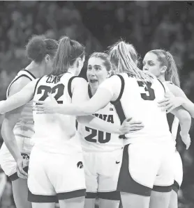 ?? JULIA HANSEN/IOWA CITY PRESS-CITIZEN ?? Iowa’s Kate Martin, middle, talks to her teammates in a huddle while playing West Virginia in an NCAA Tournament round-of-32 game Monday at Carver-Hawkeye Arena in Iowa City.