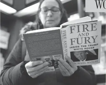  ?? CHARLES REX ARBOGAST / THE ASSOCIATED PRESS ?? Kathy Mallin, from Glenview, Ill., looks over a copy of the book Fire and Fury: Inside the Trump White House by Michael Wolff at Chicago’s Barbara’s Bookstore on Friday, the day that it went on sale.