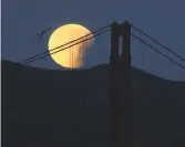  ?? Justin Sullivan / Getty Images ?? A partially eclipsed super blue blood moon behind the Golden Gate Bridge.