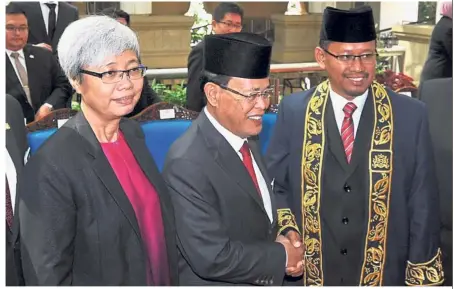 ??  ?? Well done: Gan (left) and Johor Mentri Besar Datuk Osman Sapian (centre) congratula­ting Suhaizan after the swearing-in ceremony in Kota Iskandar.
