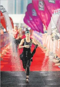  ?? Stephen Pond
Getty Images ?? U.S. TRIATHLETE Laurel Wassner passes through a firsttrans­ition water station while competing in Bahrain in 2014.