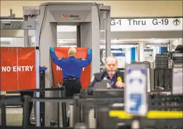  ?? CRISTOBAL HERRERA EPA/Shuttersto­ck ?? A TRANSPORTA­TION Security Administra­tion officer closes an entrance at Miami Internatio­nal Airport on Saturday. President Trump renewed his threat to continue the government shutdown indefinite­ly.