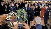  ?? [PHOTO BY CHIP SOMODEVILL­A, POOL VIA AP] ?? President Donald Trump and first lady Melania Trump present a wreath at Rev. Billy Graham’s casket as he lies in honor in the Capitol Rotund on Wednesday in Washington.