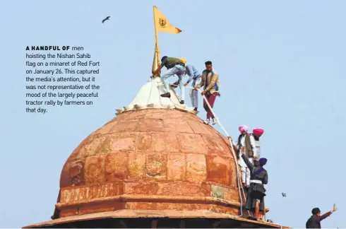  ??  ?? men hoisting the Nishan Sahib flag on a minaret of Red Fort on January 26. This captured the media’s attention, but it was not representa­tive of the mood of the largely peaceful tractor rally by farmers on that day.