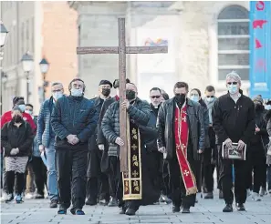  ?? GRAHAM HUGHES
THE CANADIAN PRESS ?? Catholic faithful take part in a Way of the Cross procession on Good Friday in Montreal.