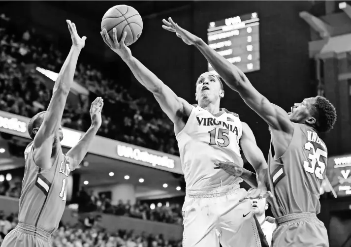  ?? GEOFF BURKE, USA TODAY SPORTS ?? Malcolm Brogdon, center, who leads Virginia with 17 points per game, and the Cavaliers face a difficult Atlantic Coast Conference game at Louisville on Saturday.
