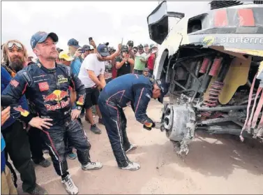  ??  ?? ENFADO. El copiloto de Loeb, Daniel Elena, estudia los desperfect­os de su Peugeot al llegar a Tacna.