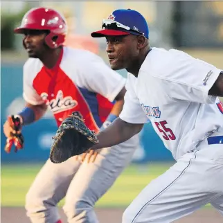  ?? JAMES PARK ?? Ottawa Champions infielder Alexander Malleta watches the play with the Cuban national team’s Raul Gonzalez on base beside him during an exhibition game Friday which the Champions won 6-1 at RCGT Park.