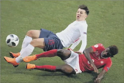  ??  ?? SLIDING IN: England’s Bobby Duncan feels the force of a challenge from Switzerlan­d’s Alexandre Jankewitz in the European Under-17s match in Rotherham.