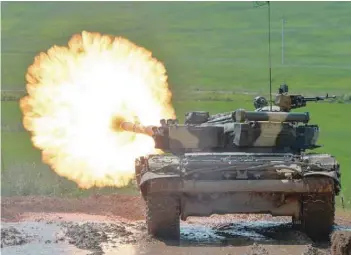  ?? — AFP ?? Saturday. A Belarus’ T-72 tank fires at a target during a tank biathlon competitio­n at Stalin’s Line museum, outside Minsk, on
