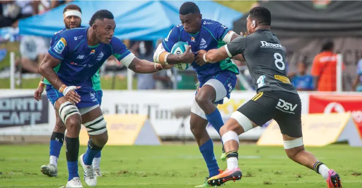  ?? Photo: Leon Lord ?? Swire Shipping Fijian Drua winger Taniela Rakuro (with ball) fends off Hurricanes captain Ardie Savea while Vilive Miramira (left) offers his support during their Shop N Save Super Rugby Pacific Round 11 match at the HFC Bank Stadium on May 6, 2023. The Drua defeated Hurricanes 27-24.