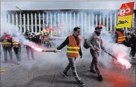  ?? Claude Paris ?? The Associated Press Protesters hold flares during a demonstrat­ion Wednesday outside the Saint Charles train station in Marseille, southern France.