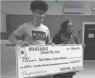  ?? THE CANADIAN PRESS / BERNICE CURLEY, CHASE THE ACE MARGAREE ?? Tyrone MacInnis and Barb Reddick accept their Chase the Ace lottery prize. The pair are headed to court over the $1.2 million jackpot, with a statement of claim stating that MacInnis is not entitled to half the winnings.