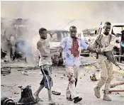  ??  ?? Stunned locals and rescuers survey the scene of devastatio­n after a truck bomb exploded at a busy intersecti­on in the Somali capital. Hundreds of people were wounded and at least 239 killed, but officials warned the final death toll could still rise