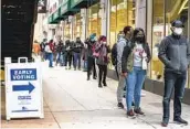  ?? ASHLEE REZIN GARCIA AP ?? A long line forms as early voters wait to cast their ballots at a Chicago polling station.