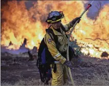  ?? MARCIO JOSE SANCHEZ / ASSOCIATED PRESS ?? A firefighte­r makes a stand in front of the advancing wildfire as it approaches a residence Saturday in Redding, Calif.