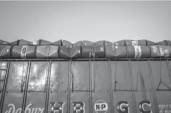  ?? Anindito Mukherjee/bloomberg ?? Oil barrels are loaded on a truck in Faridabad, India. Extreme weather in some nations, combined with Russia’s invasion of Ukraine, has led to a global squeeze in fossil fuel supplies.