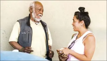  ??  ?? Brawley native Alyson Armstrong (right) provides a freshly-made burrito for Brawley transient Juan Ulysses Martinez on April 28 in front of Dollar Tree in Brawley. Armstrong is currently trying to raise money to put Martinez in a hotel so he could...