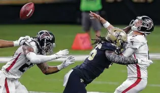  ?? Brett Duke / Associated Press ?? Falcons quarterbac­k Matt Ryan, right, is hit by Saints Demario Davis during the first half of Sunday’s game at New Orleans. The Saints sacked Ryan eight times en route to a 24-9 victory.