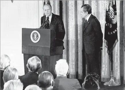  ?? GETTY-AFP ?? House Minority Leader Gerald Ford, left, speaks as President Richard Nixon looks on in October 1973. Ford became vice president later that year after Spiro Agnew resigned because of a tax crime. Ford then pardoned Nixon in 1974 about a month after he resigned in the wake ofWatergat­e.