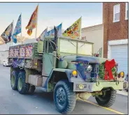  ?? (Courtesy Photo/Mallory Weaver) ?? Jason Curtis, driving his big Army transport truck, won the trophy for entry with the best use of lights in the Christmas parade. The truck, flying several colorful flags, was festooned with a wreath on the front grille and lights interlaced alongside the bed.