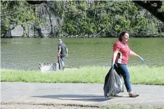 ?? Picture: SUPPLIED ?? CLEANING UP: Community members picking up bags of litter at the Batting Bridge picnic site, which has turned into a drinking and partying spot.