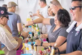  ??  ?? Servers, including Omar Gonzales, right, and Erica Doolittle, second from right, fill wine glasses at Ponderosa Valley Winery’s tent during the Albuquerqu­e Wine Festival on Saturday. Organizer Dean Strober said he expected from 11,000 to 13,000 people...
