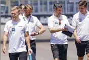  ?? AP ?? Haas driver Kevin Magnussen (left) walks the track with crew members as teams prepare for the Formula One Miami Grand Prix on Sunday in Miami.