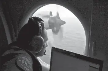  ?? ROB GRIFFITH/ASSOCIATED PRESS ?? Flight officer Rayan Gharazeddi­ne searches for missing Malaysia Airlines Flight MH370 in 2014.